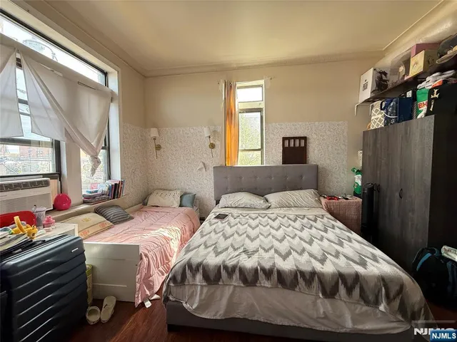 a bedroom with two beds and a window