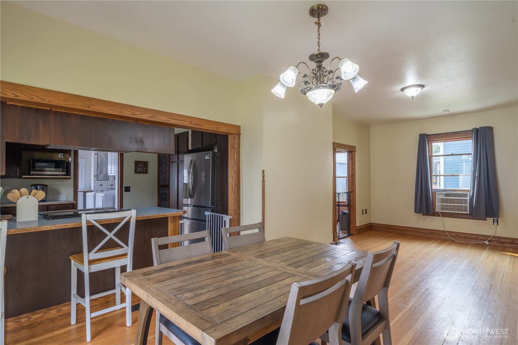 407 West 4th Avenue Ritzville, WA 99169 - Photo 11 of 40 a dining room with wooden floor a chandelier a wooden table and chairs