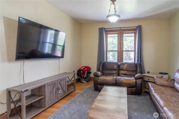 a living room with furniture a flat screen tv and a window