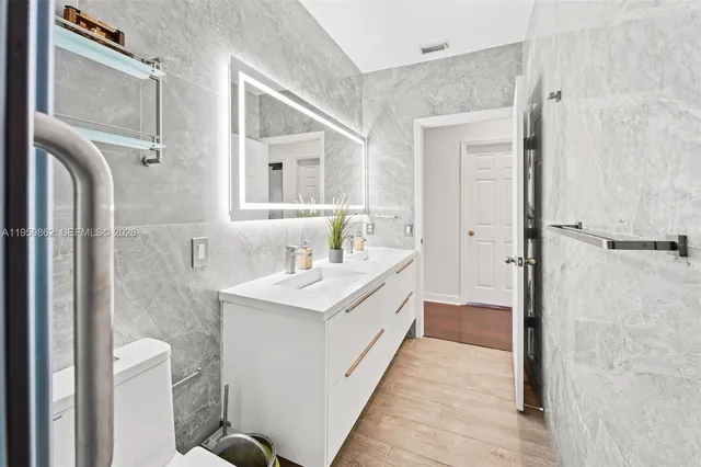 a kitchen with stainless steel appliances granite countertop white cabinets a sink and dishwasher