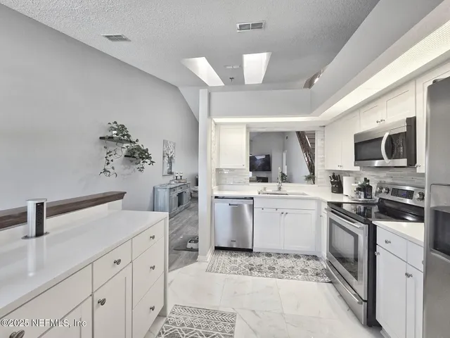 a kitchen with a sink stainless steel appliances and cabinets