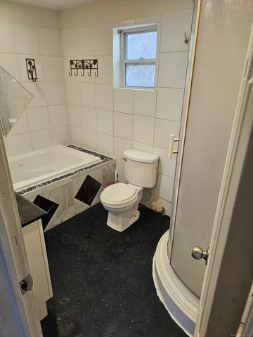 a bathroom with a toilet and a shower