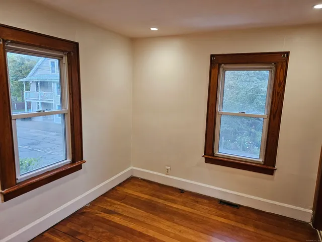 a view of a hallway with wooden floor and front door