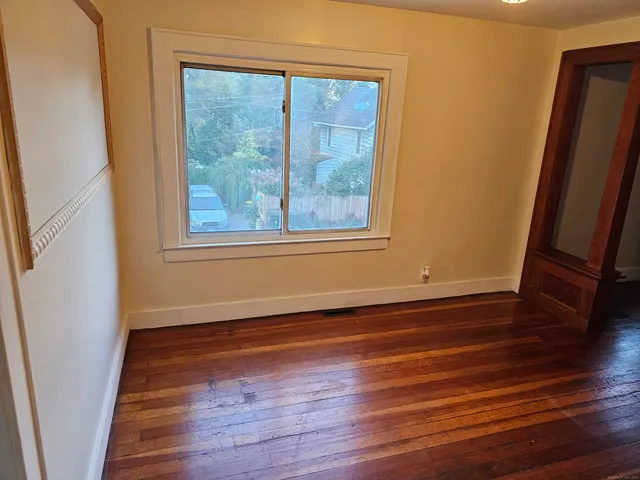 a view of a room with wooden floor and window