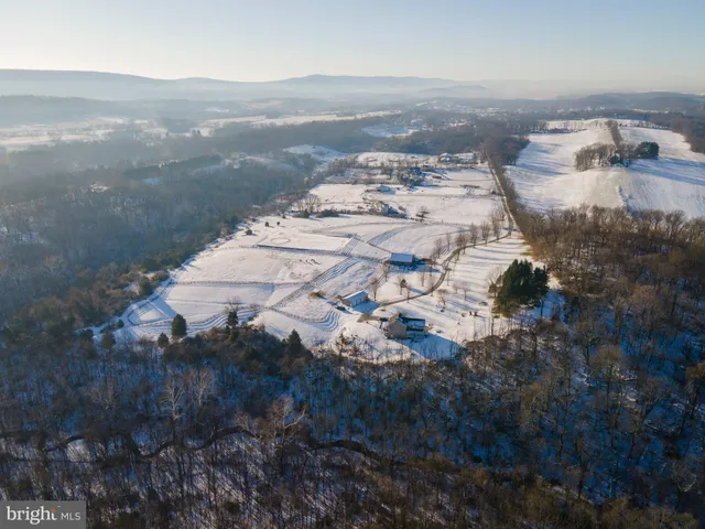 a view of a kitchen with kitchen island granite countertop wooden floors and a view of living room