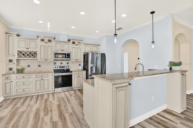a view of an empty room with wooden floor and stairs