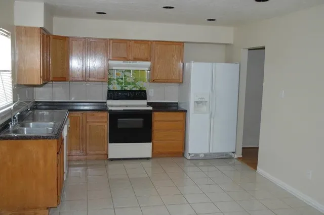 a kitchen with granite countertop cabinets and stainless steel appliances