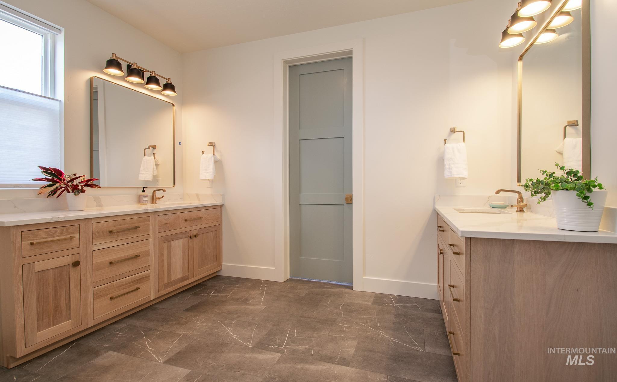 44 Big Moose Road McCall, ID 83638 - Photo 20 of 50 Bathroom featuring dual wood-finish vanities with white countertops, bronze-finish fixtures, and square mirrors