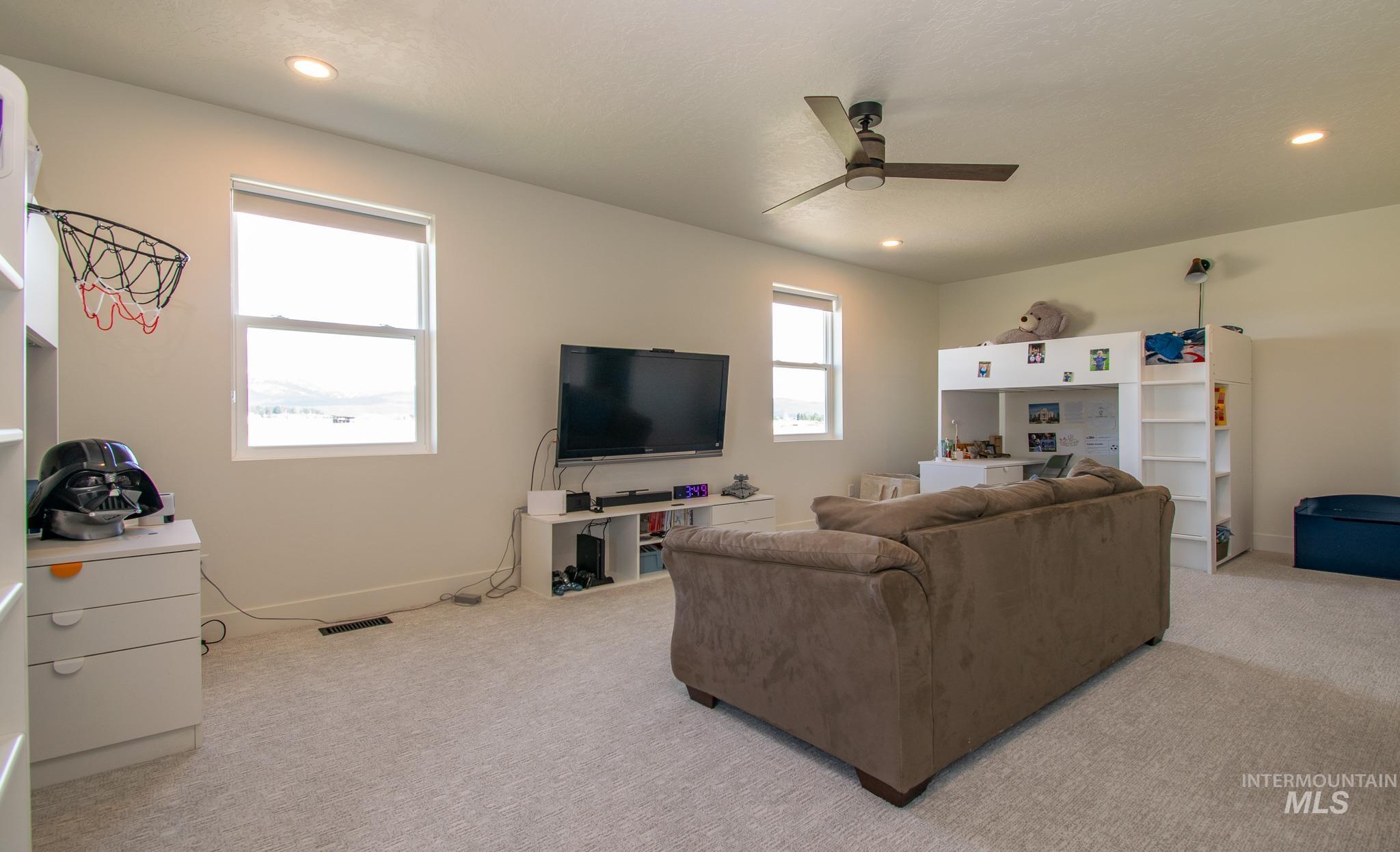 44 Big Moose Road McCall, ID 83638 - Photo 34 of 50 Spacious room featuring light-colored carpet, multiple windows providing natural light, recessed ceiling lighting, and a ceiling fan