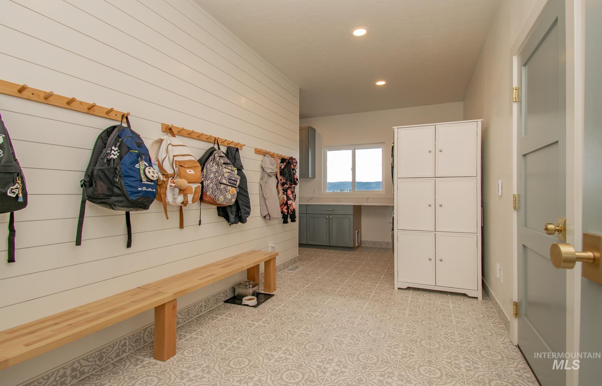 44 Big Moose Road McCall, ID 83638 - Photo 37 of 50 Spacious mudroom featuring shiplap accent wall, built-in wooden bench, patterned floor tiling, recessed lighting, and a window with natural light