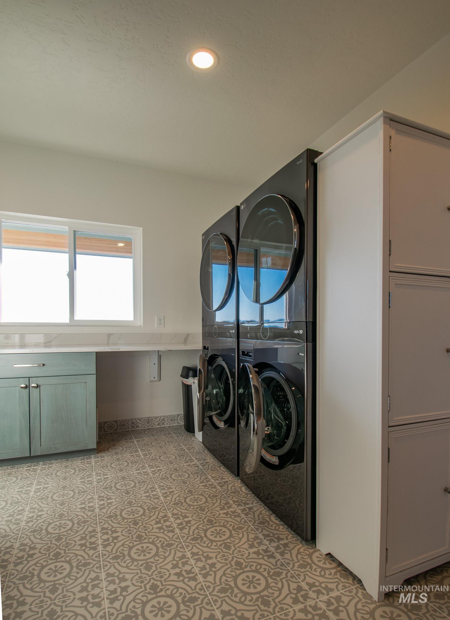 44 Big Moose Road McCall, ID 83638 - Photo 40 of 50 Utility room featuring patterned tile flooring, a built-in countertop with an undermount cabinet, a large window, and recessed lighting