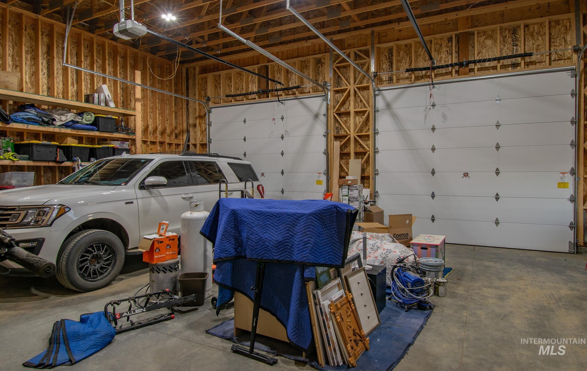 44 Big Moose Road McCall, ID 83638 - Photo 45 of 50 Spacious two-bay garage featuring exposed wood framing, concrete flooring, and overhead lighting