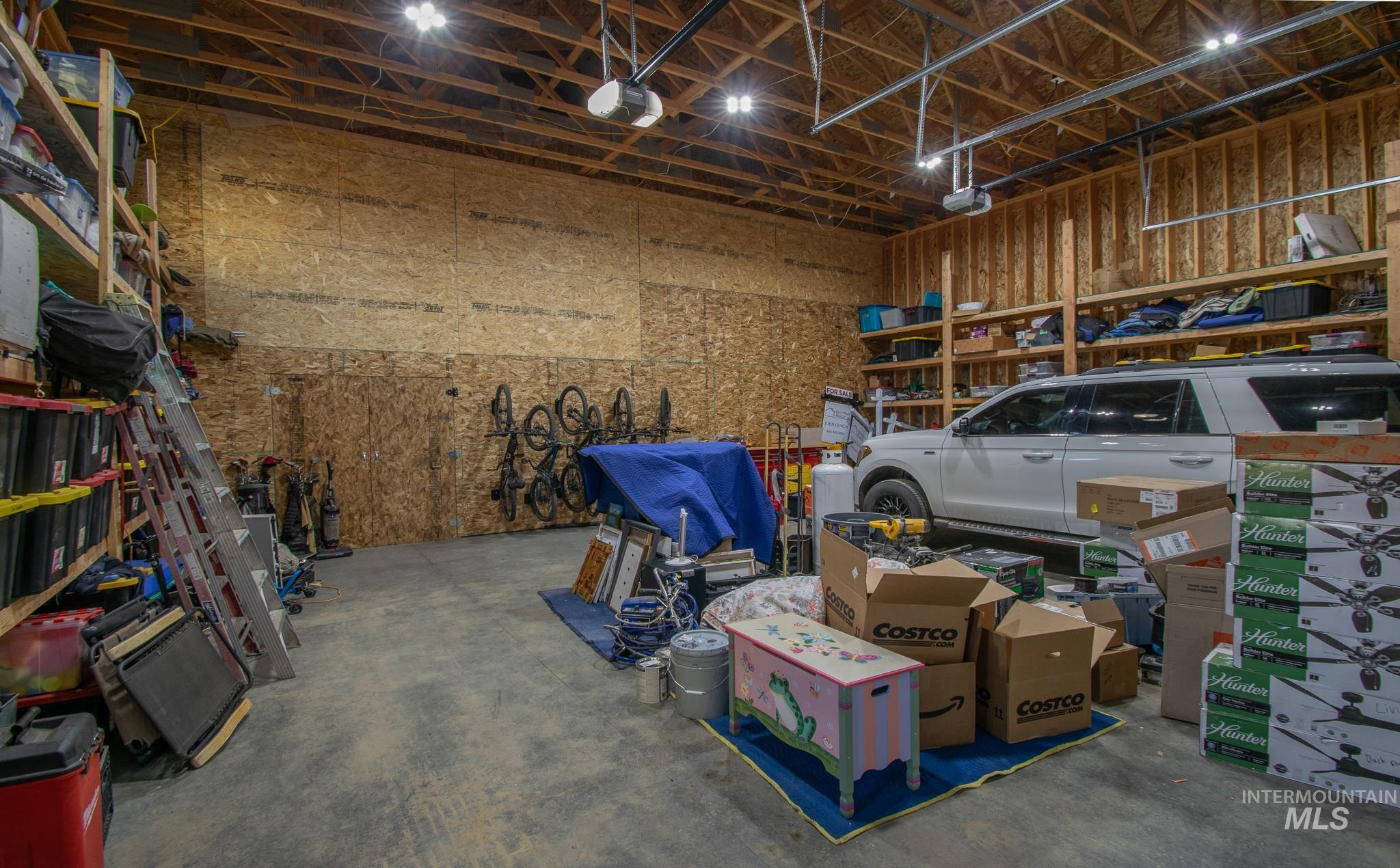 44 Big Moose Road McCall, ID 83638 - Photo 46 of 50 Spacious garage featuring exposed wood framing, high ceilings with visible rafters, and overhead lighting
