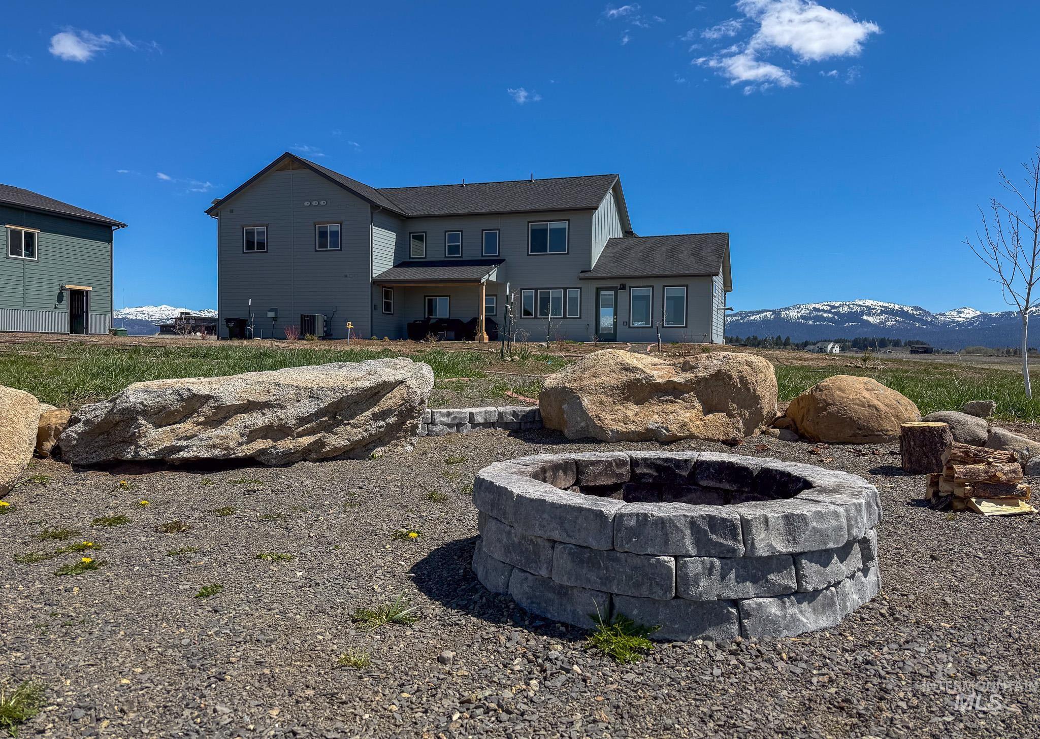44 Big Moose Road McCall, ID 83638 - Photo 50 of 50 Expansive outdoor space featuring a built-in stone fire pit, large natural boulders, and a gravel ground cover