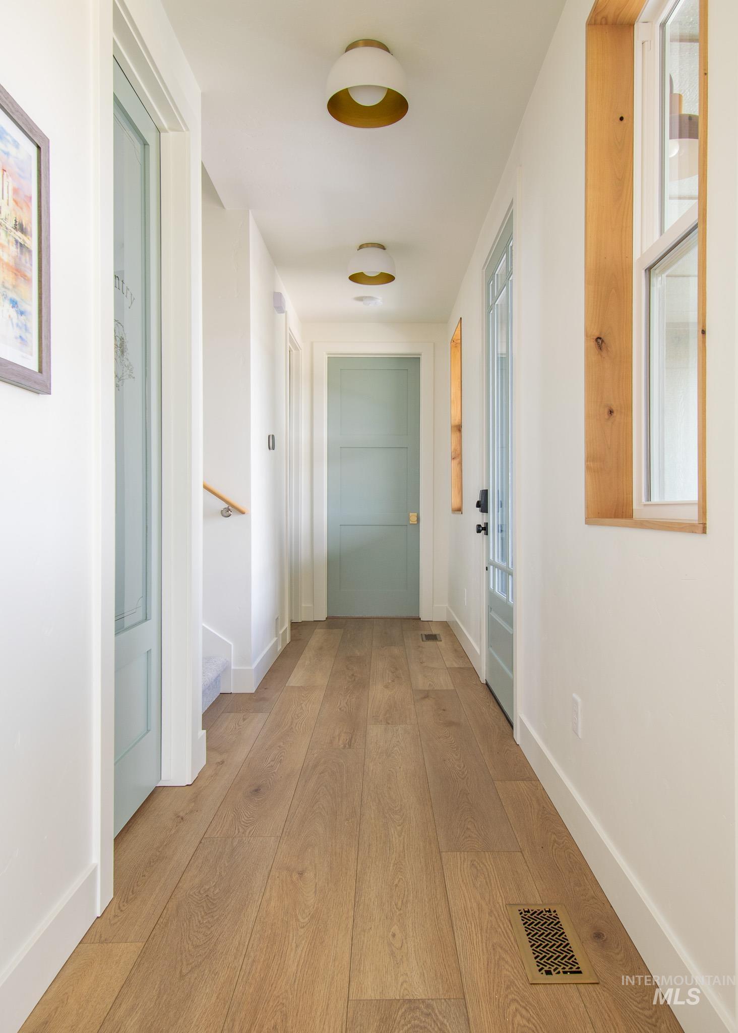 44 Big Moose Road McCall, ID 83638 - Photo 5 of 50 Hallway featuring wide plank wood-finish flooring, white walls, and light-colored doors