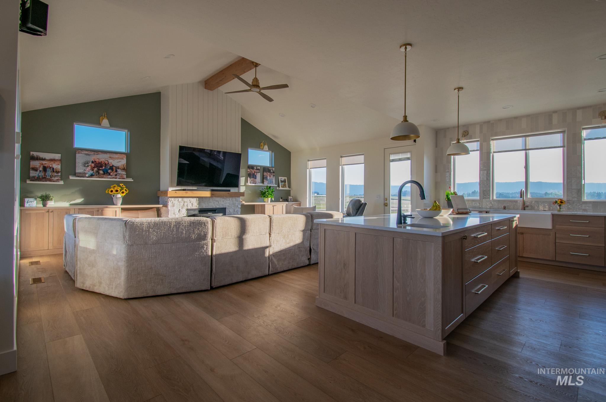 44 Big Moose Road McCall, ID 83638 - Photo 6 of 50 Open-concept living space featuring wood-finish flooring, a kitchen island with a quartz countertop, recessed lighting, and a vaulted ceiling with an exposed beam
