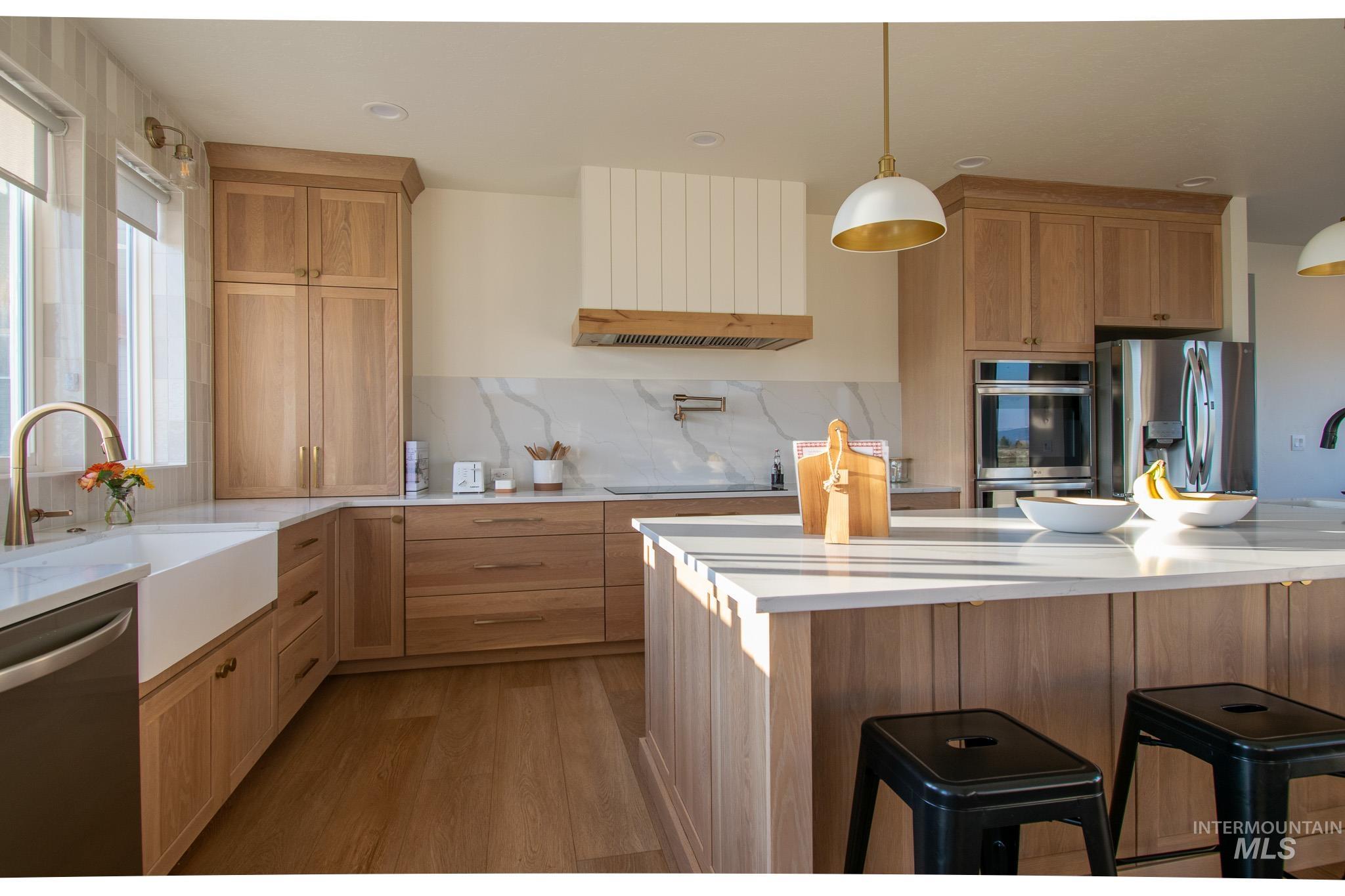 44 Big Moose Road McCall, ID 83638 - Photo 8 of 50 Modern kitchen featuring light wood cabinetry, white countertops, an integrated farmhouse sink, and stainless steel double ovens