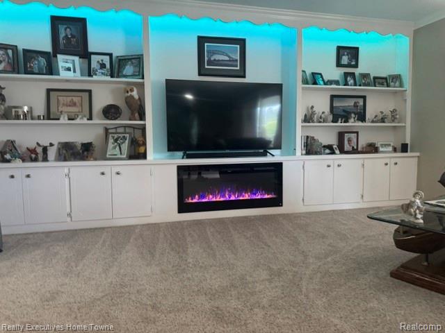 1467 Krafft Road, Unit 8 Port Huron, MI 48060 - Photo 5 of 28 Built-in entertainment center featuring shelving, cabinet storage, an integrated electric fireplace, and accent lighting