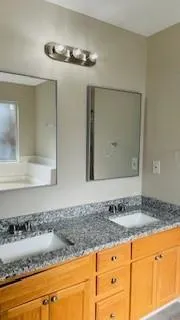 a bathroom with a granite countertop sink and a mirror