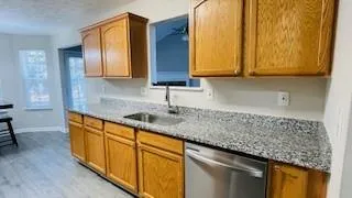 a kitchen with stainless steel appliances granite countertop wooden cabinets a sink and dishwasher