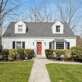 a front view of a house with a garden and plants
