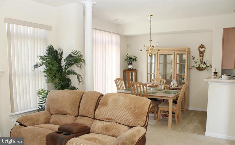 9878 Dochart Sound Lane Bristow, VA 20136 - Photo 12 of 30 a living room with furniture a chandelier and a dining table