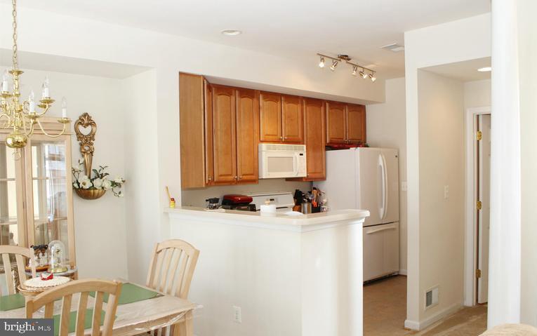 9878 Dochart Sound Lane Bristow, VA 20136 - Photo 15 of 30 a kitchen with a refrigerator a stove top oven a sink and a window