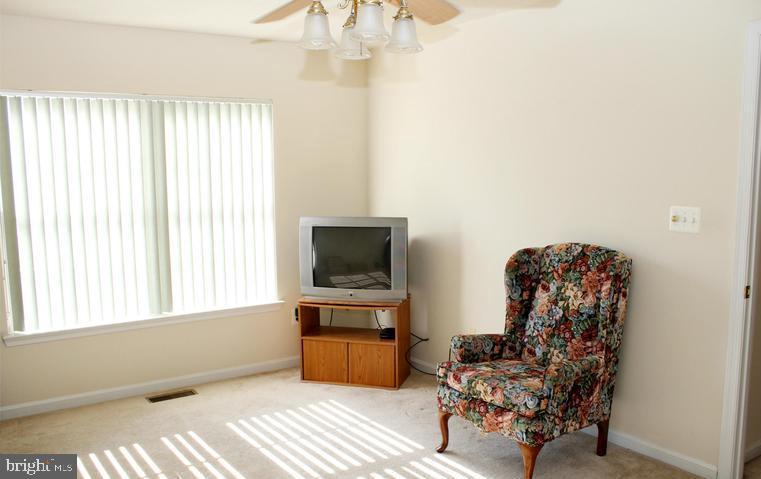 9878 Dochart Sound Lane Bristow, VA 20136 - Photo 24 of 30 a living room with furniture and a flat screen tv