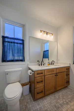 a bathroom with a toilet a sink and mirror