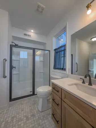 a bathroom with a sink a toilet and shower