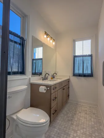 a bathroom with a toilet a sink and mirror