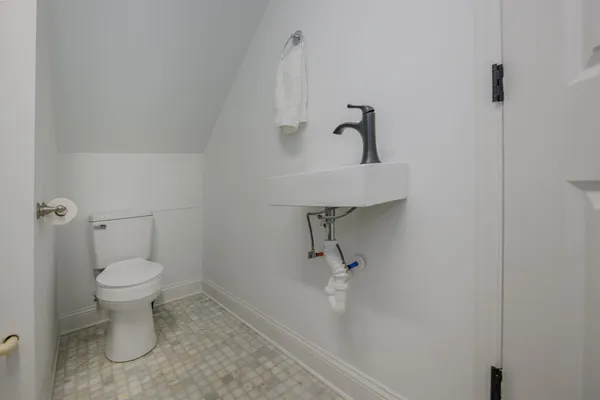 a bathroom with a toilet sink and a mirror