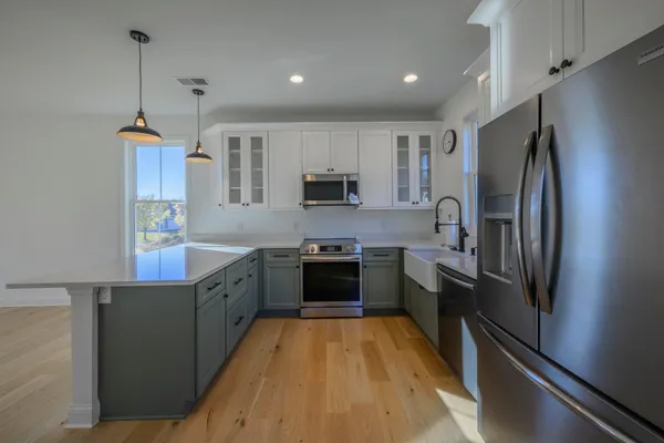 a large kitchen with stainless steel appliances granite countertop a refrigerator a stove a sink and a microwave