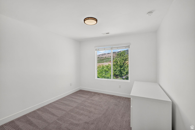 6536 West Muirfield Road Highland, UT 84003 - Photo 17 of 48 Bright room with a large window, neutral carpeting, and a flush-mount ceiling light