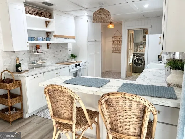 a kitchen with stainless steel appliances granite countertop a stove top oven a sink a dining table and chairs with wooden floor