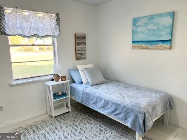 a bedroom with a bed and two windows