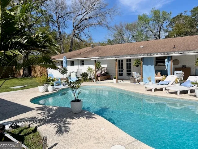 a view of a house with swimming pool and sitting area