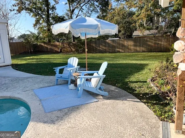 a view of a table and chairs in backyard of the house
