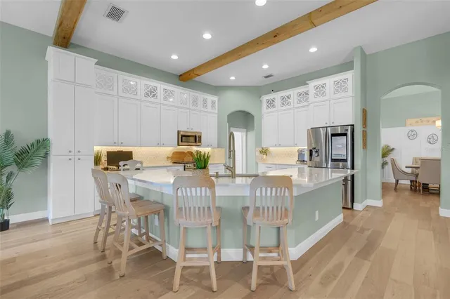 a kitchen with granite countertop white cabinets stainless steel appliances and sink