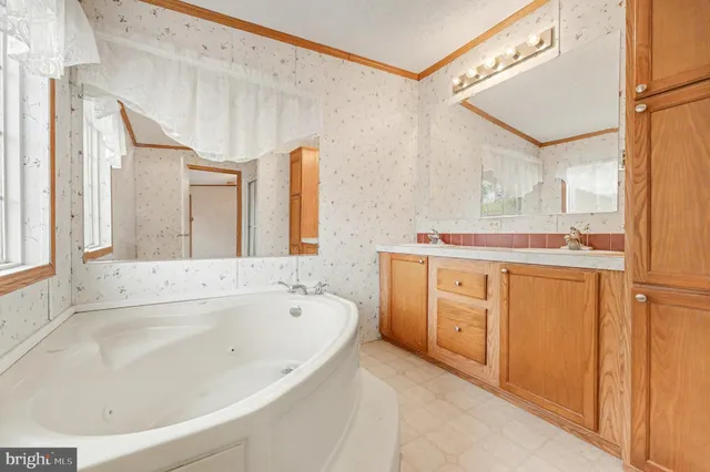 a spacious bathroom with a tub sink and mirror