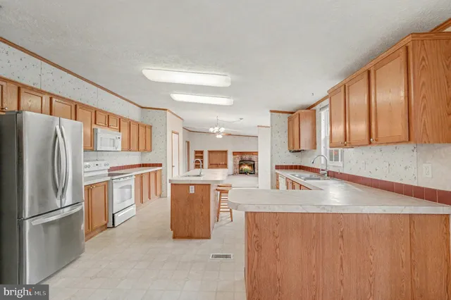 a kitchen with stainless steel appliances granite countertop a refrigerator a stove top oven a sink and dishwasher
