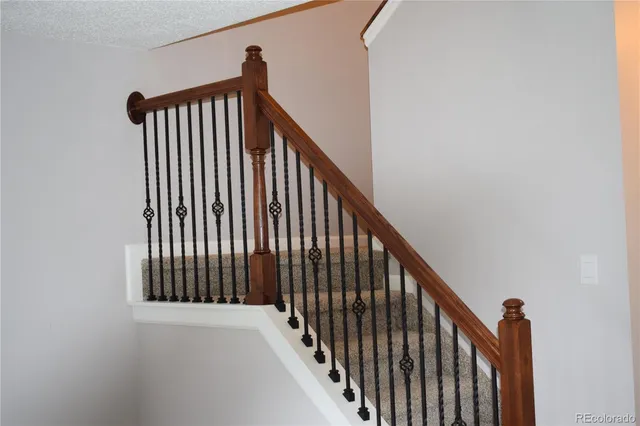 a view of staircase with railing and a window