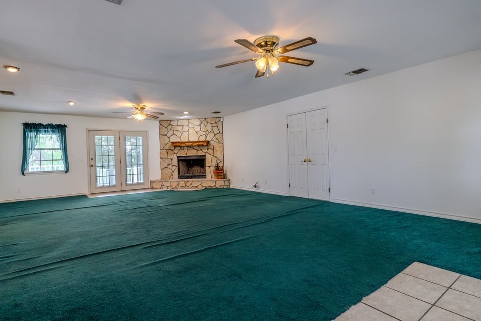 483 Riverside Drive Palacios, TX 77465 - Photo 11 of 41 a view of a livingroom with a fireplace a ceiling fan and wooden floor