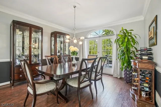 a dining room with furniture a chandelier and wooden floor