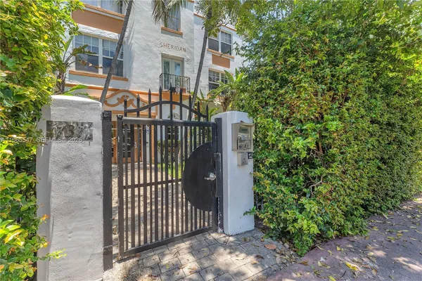 a view of a brick house with a large window and potted plants