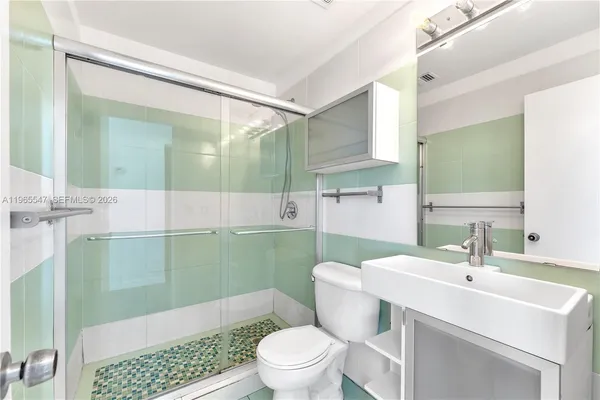 a bathroom with a sink mirror toilet and shower