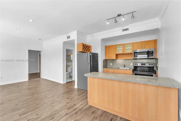 a large kitchen with stainless steel appliances a large counter top and a stove top oven