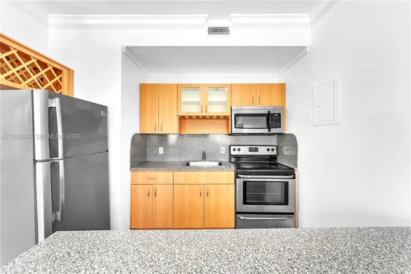 a kitchen with stainless steel appliances granite countertop a refrigerator and a stove