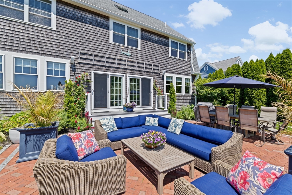 38 Gilson Road Scituate, MA 02066 - Photo 36 of 42 a view of a patio with couches table and chairs under an umbrella