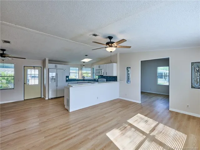a view of a kitchen with a sink dishwasher and a kitchen view with wooden floor